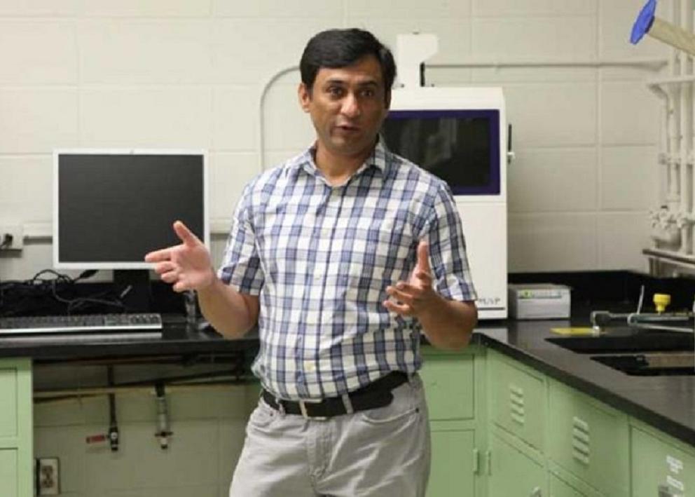 Dr. Raza speaks to students from the corner of the lab